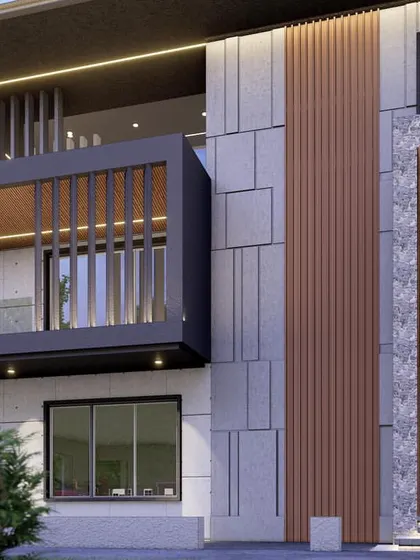 The entrance detail of the 600 sq. yard residence. A grand, recessed entryway clad in wood provides a warm contrast to the stone and concrete exterior, with integrated lighting for dramatic effect.