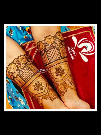 A close-up of the arm design, featuring bold lotus motifs inside elegant frames, combined with delicate net-like patterns.
