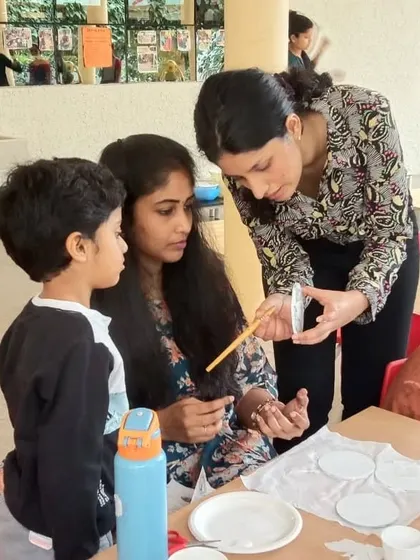An instructor helping a mother and son with their decoupage project.