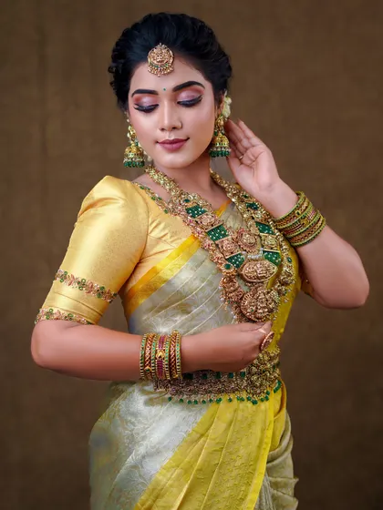 This silver and yellow silk saree creates a unique and elegant look. The draping is done to show off the beautiful contrast border and the richness of the silk.
