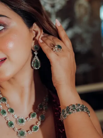 A close up on the details. This shot highlights the stunning emerald jewelry and the glamorous eye makeup, perfect for a Sangeet or party look.