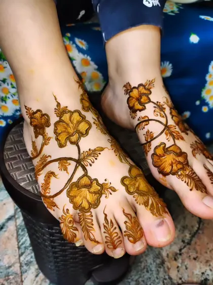 A close-up of the floral vine foot design, showing the delicate lines and shading.