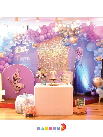 Another magical Frozen setup, complete with a light-up number, a sparkling sequin backdrop, and beloved characters like Elsa and Olaf, ready to celebrate.