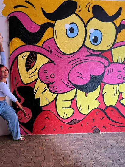 Me striking a yoga pose next to my Courage mural. Art and movement often go hand in hand for me.