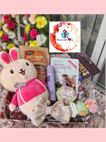A playful and cute hamper featuring a large bunny plush toy, oat chips, a bow, and other fun accessories, perfect for the young at heart.