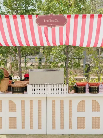 A food stall with a red and white striped awning, part of a Parisian market theme for a creative and fun Haldi celebration.