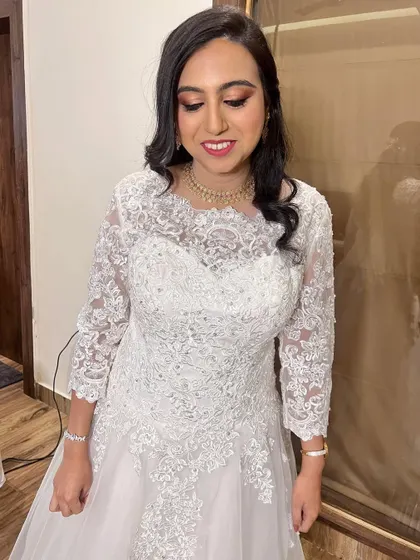 A smiling shot of Meghana, looking happy and radiant. Her soft curls and simple necklace complete this understated and elegant Christian bridal look.