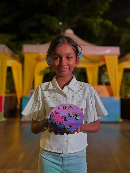 This young lady is thrilled with her unicorn-themed creation. The joy of making something with your own hands is a universal feeling.