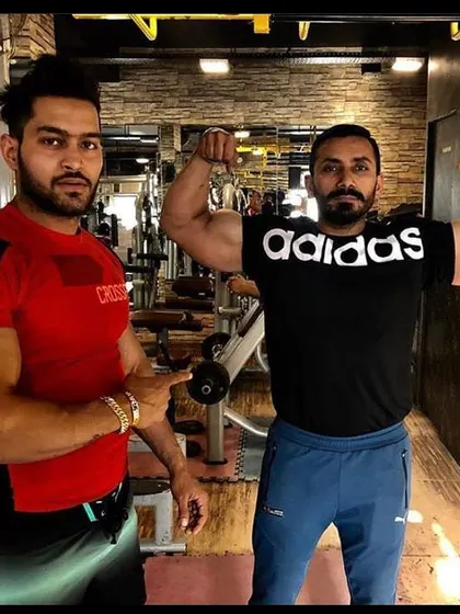 Coaching in action. Here I am with a client, guiding his form and celebrating his progress right on the gym floor.
