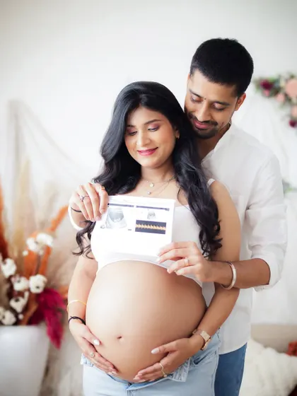A happy couple proudly showing their sonogram picture. This shot perfectly captures the excitement of seeing their baby for the first time.