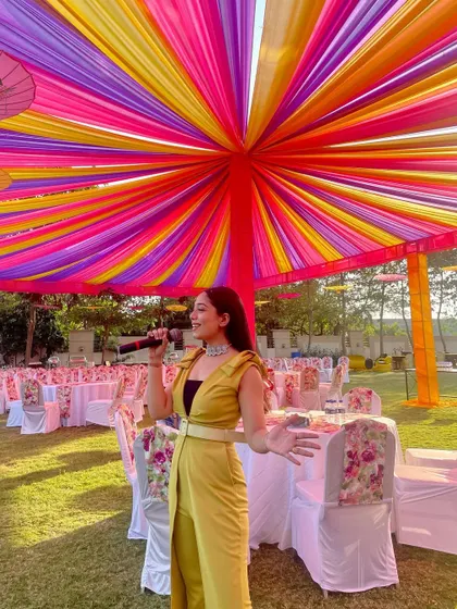 Pausing for a quick mic test before the show begins. This yellow jumpsuit was perfect for a colorful outdoor Mehendi party.