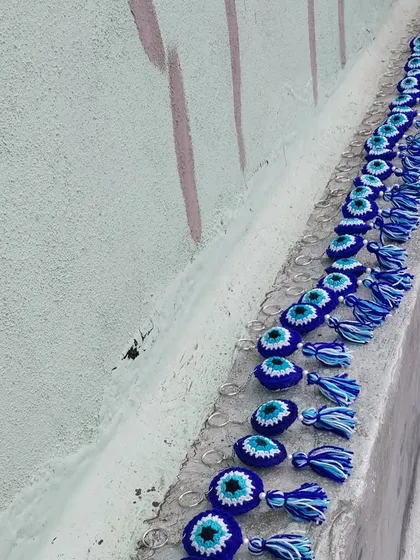 A long line of finished evil eye keychains, showing the consistency and quality I maintain across bulk orders.