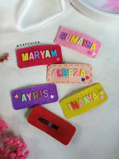A close-up of the back of our felt name clips, showing the secure snap clip we use to ensure they stay in place.
