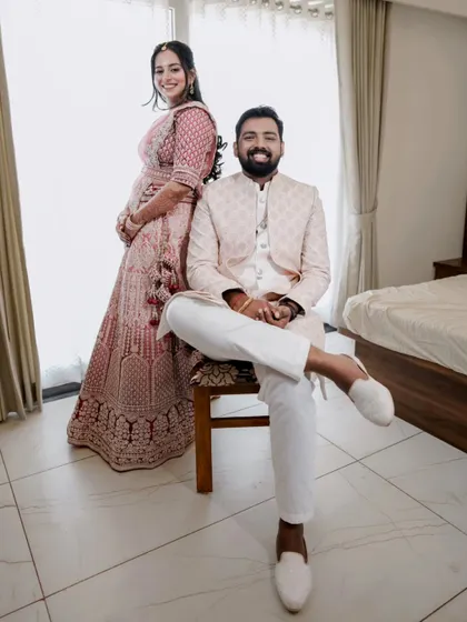 A stylish, full-length portrait of a couple at their reception, showcasing their elegant outfits.