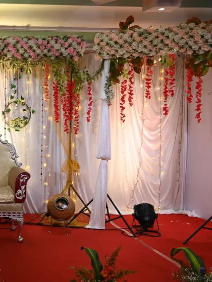 A duplicate image of the stage with hanging pink and red florals.