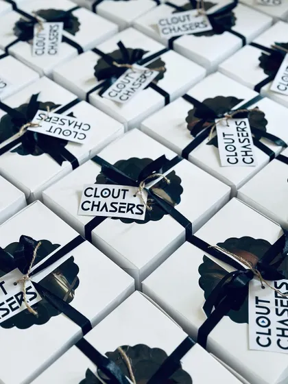 An angled view of the 'Clout Chasers' gift boxes, emphasizing the striking design and large quantity prepared for their event.