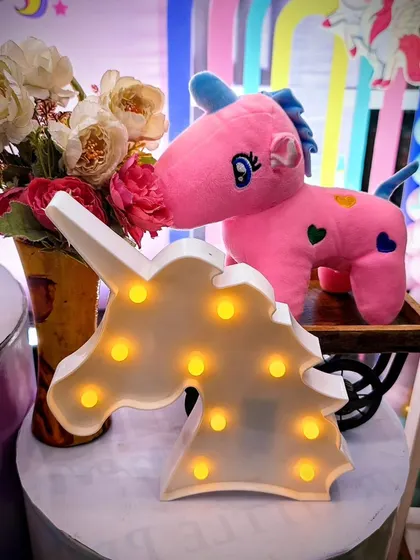 A light-up unicorn head marquee sign adds a magical glow to the party decor.