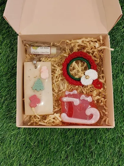 Another view of a beautifully packed Christmas gift box, showcasing a crochet wreath and other curated goodies, ready to be sent to a loved one.