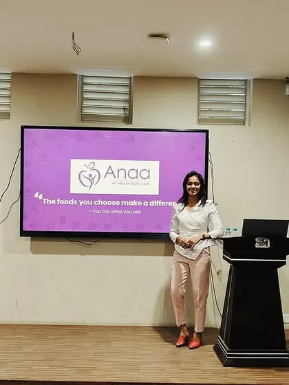 A full view of the stage setup at Dayananda Sagar Business School. The screen displays the Anaa Nutricare logo, representing my commitment to providing professional and impactful health education.