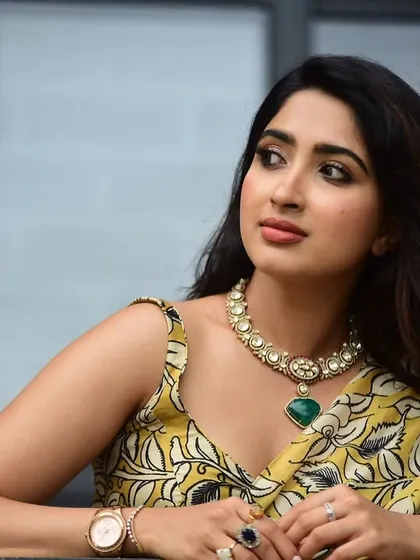 A close-up portrait of the actress, the green of the necklace beautifully picking up the tones in her saree.
