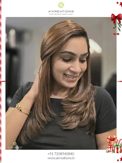 Our client smiling, clearly happy with her new almond brunette highlights and fresh, layered haircut.