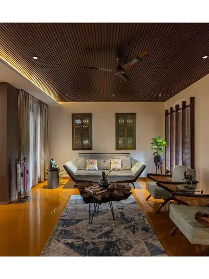 The living room in "Between Two Trees" features a polished Jaisalmer stone floor, whose golden hue brings incredible warmth to the space. The ceiling is finished with dark wood slats for contrast.