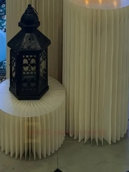 A detail shot from an "Oh Baby" shower, showing modern fluted pedestals and a decorative lantern prop.