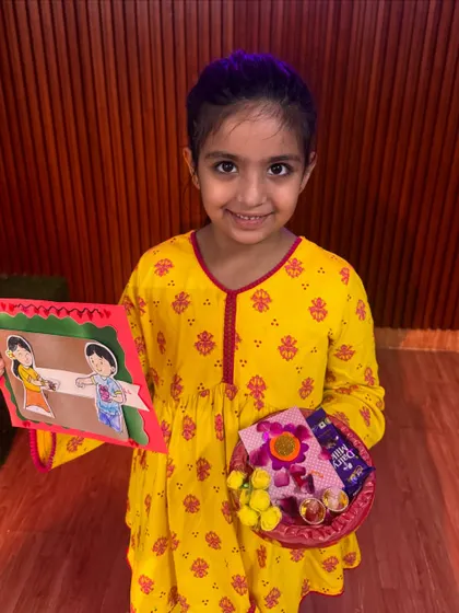 Look at that happy face. This student is ready for Rakhi with her handcrafted card and a decorative thali, complete with a rakhi and sweets.