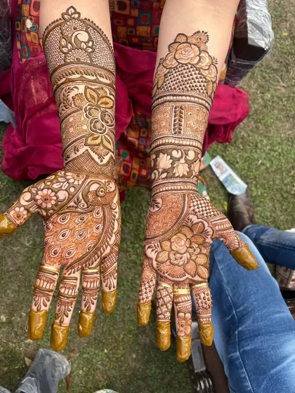 This design showcases two of the most beloved traditional motifs. One hand features a large, detailed peacock, while the other has a beautiful blooming floral mandala.