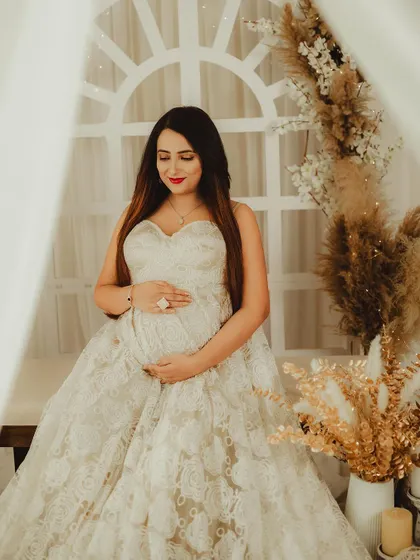 Framed by the arched window prop, this portrait has a beautiful, classic feel. The lace gown and pampas grass decor add to the soft, romantic vibe.