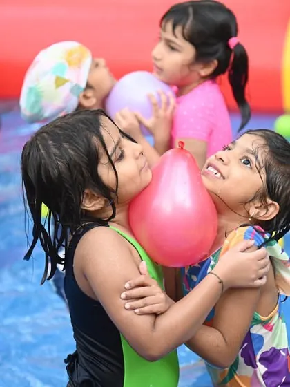 Best friends sharing a hug and a balloon at a pool party. It's all about making fun memories together.