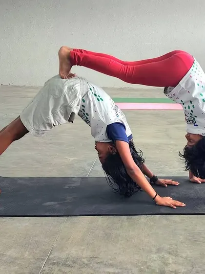 The vibrant colors and strong lines in this partner pose highlight the dynamic energy of our acro-yoga sessions.