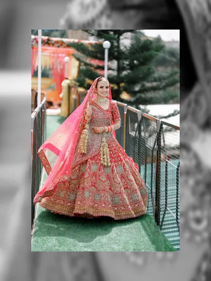 A full-length portrait of the bride on a bridge, showcasing her beautiful red lehenga against the backdrop of the resort.
