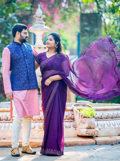 An elegant outdoor portrait with the bride's purple saree flowing beautifully in the breeze.
