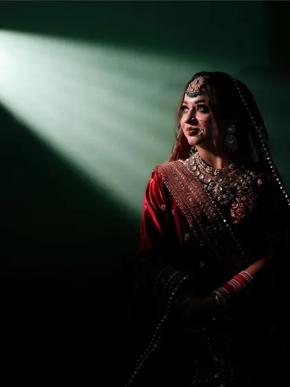 I love playing with light to create something truly magical. This dramatic bridal portrait uses a single beam of light to highlight the bride's anticipation and elegance just moments before her ceremony.