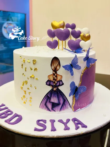 A dreamy cake for Siya's birthday in shades of purple. It features an elegant illustration of a girl in a gown, with edible butterflies and a cascade of purple and gold hearts.