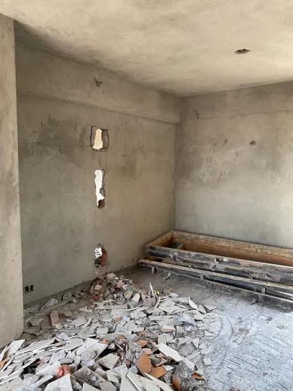 The 'before' state of the family lounge at Logix Blossom, a raw space filled with debris.