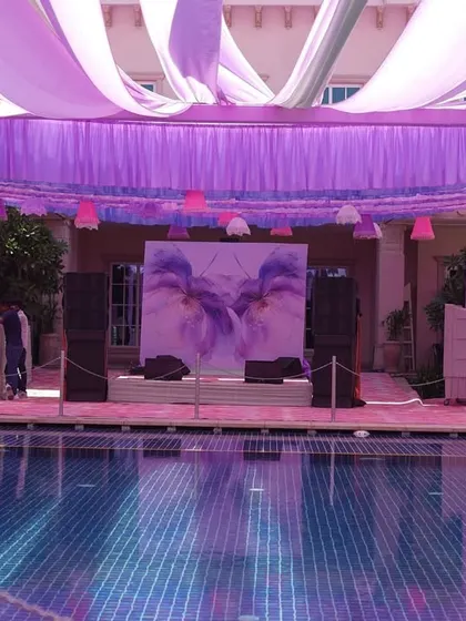 The stage, set against the pool, featured a beautiful watercolor-style floral backdrop. The entire setup, with its pastel drapes and reflections, created a truly magical atmosphere for the performances.