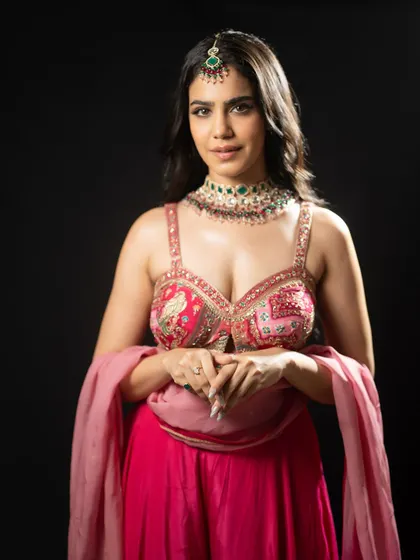A close-up portrait focusing on the detailed work on the bustier and the complementary ethnic jewelry.