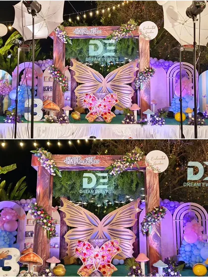 An enchanting outdoor butterfly garden theme at night, illuminated with professional lighting to highlight the magical stage and decorations.