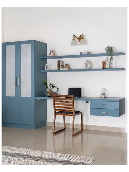 The guest bedroom, featuring a built-in study nook and wardrobe in the same calming blue hue. Faux walls were used to conceal a roomy walk-in wardrobe, providing ample storage.