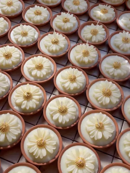 Another angle of the daisy candles, capturing the sunlight on their petals. These are a truly special festive gift.