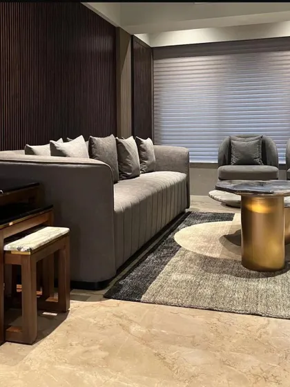 A view of the living room in the Juhu apartment, where I used a combination of soft textiles, dark wood paneling, and a graphic rug to create a space that is both comfortable and visually sophisticated.
