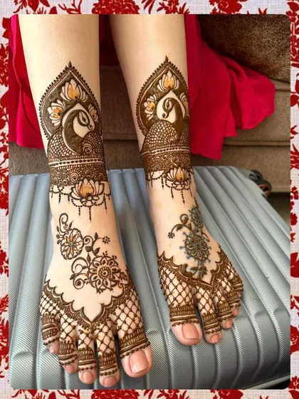 A unique and artistic foot design for a bride, featuring peacocks and floral elements with a mix of dense and open spacing.
