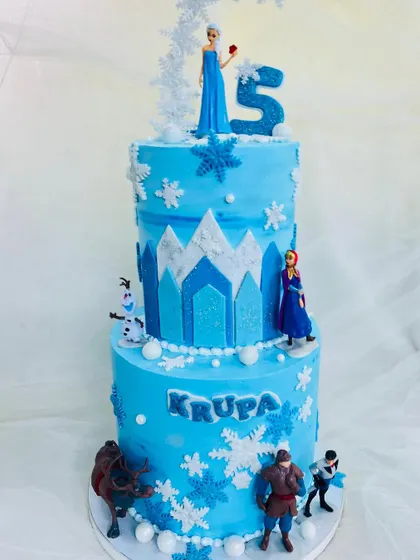 A full view of the two-tier Elsa cake, showcasing the hand-piped snowflakes and the different shades of blue I used to create a sense of icy depth.