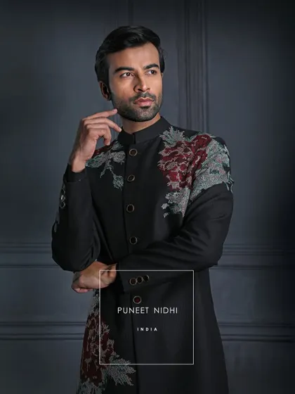 Beyond fabric, this black achkan is a portrait of tradition in modern light. Vintage roses whisper of elegance eternal, created for the man who defines class by the legacy he carries.