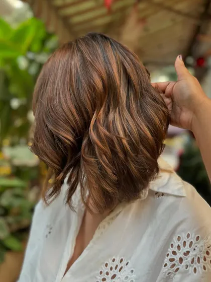 A close-up on the brown sugar tones. The waves add a playful touch to this sophisticated cut and color. (No filter)