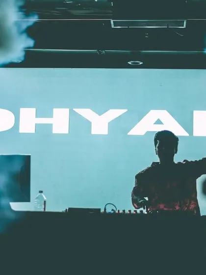 A silhouette shot of me against my name in lights. This image captures the powerful, immersive experience of my club sets, where music and visuals come together.