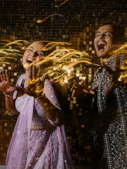 Another fantastic long-exposure shot of the couple laughing and dancing. The golden light trails perfectly match the high-energy, celebratory mood of the Sangeet.