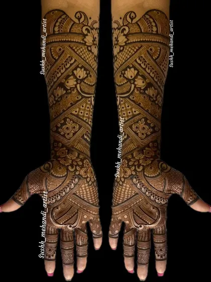 This is a very dense and intricate bridal design, where every space is filled with detail. The patterns flow beautifully from the fingers to the elbows.